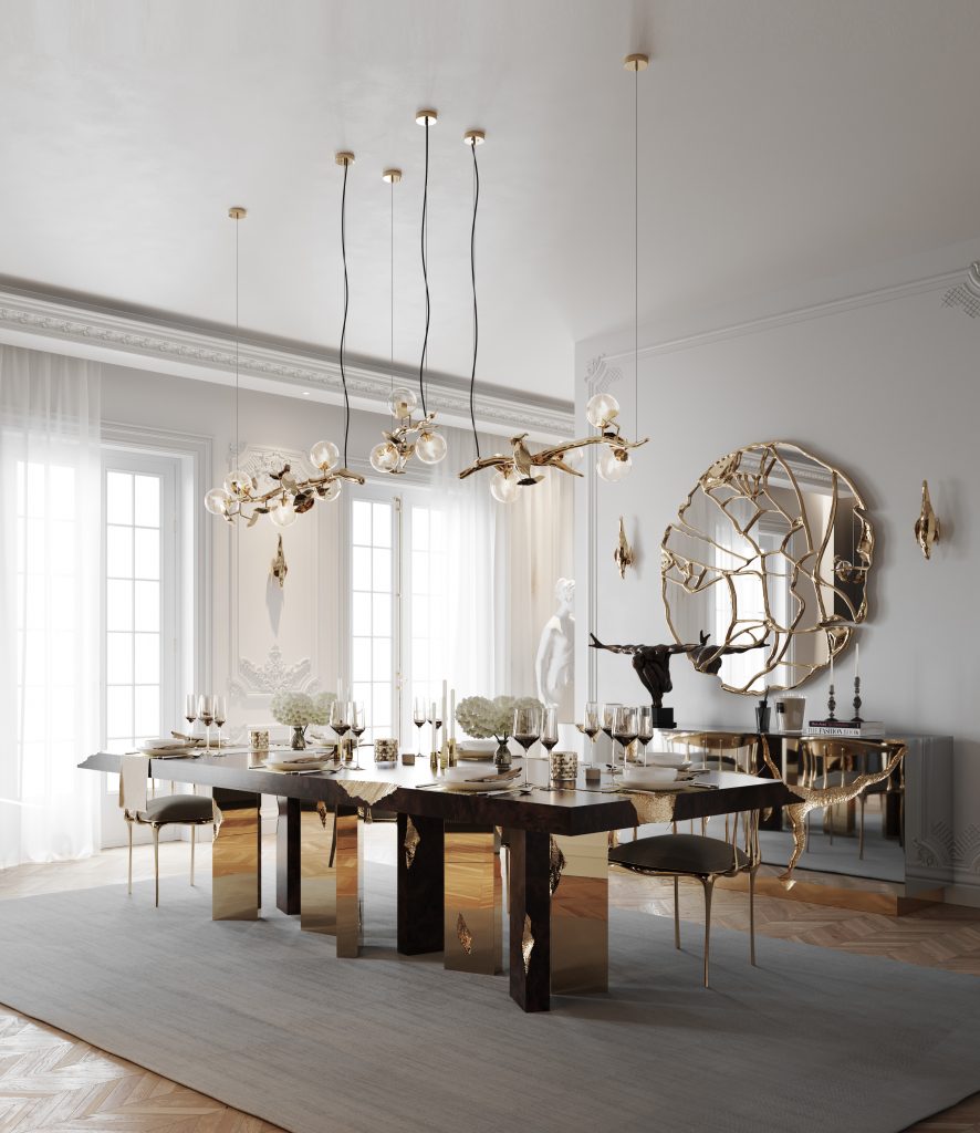 Luxury Dining Table - modern dining room, white walls, windows with white curtains, round mirror with gold details and a brown dining table with gold details, with glasses, plates and decorative candles and black and gold chairs.